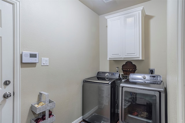 laundry area with washer and dryer and cabinets