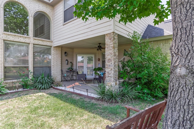 entrance to property featuring a yard and ceiling fan