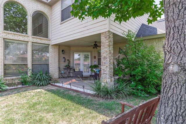 property entrance with brick siding, a ceiling fan, french doors, roof with shingles, and a patio area