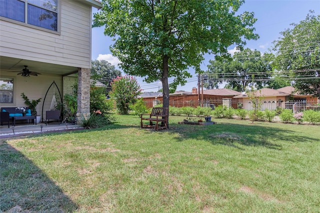 view of yard with ceiling fan and fence