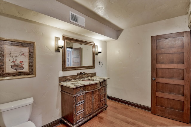 bathroom featuring hardwood / wood-style floors, toilet, and vanity