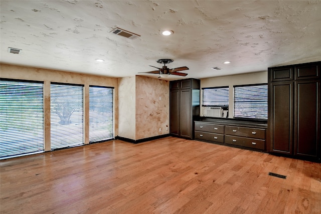 unfurnished bedroom with cooling unit, ceiling fan, light wood-type flooring, and multiple windows