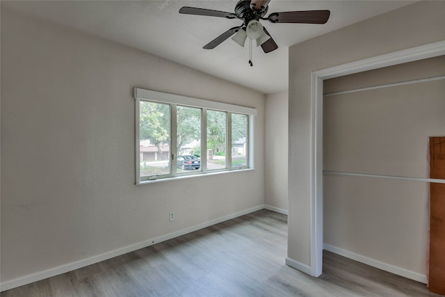 unfurnished bedroom with hardwood / wood-style floors, ceiling fan, and a closet