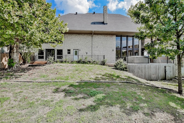 rear view of property with a lawn