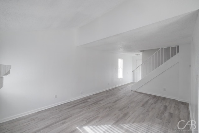 spare room featuring a textured ceiling and light hardwood / wood-style flooring