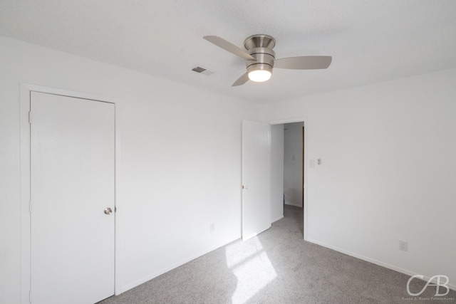 unfurnished bedroom with ceiling fan, light colored carpet, and a closet