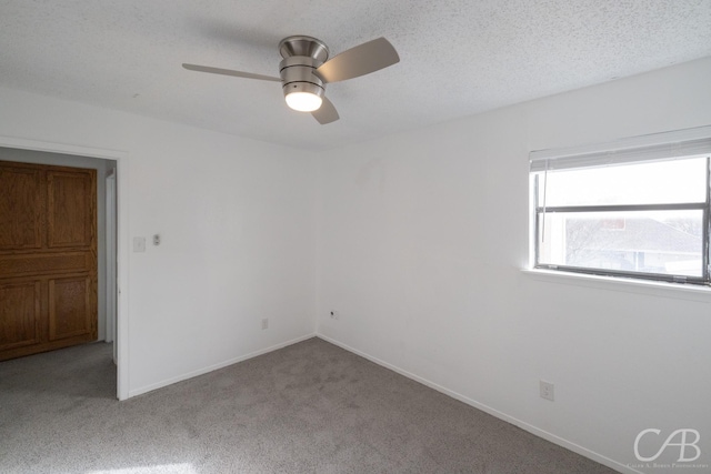 unfurnished room featuring ceiling fan, light colored carpet, and a textured ceiling