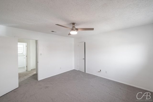 empty room featuring carpet floors, ceiling fan, and a textured ceiling