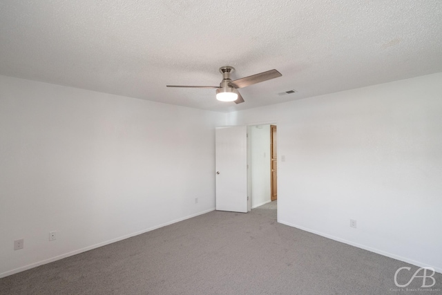 carpeted spare room with a textured ceiling and ceiling fan