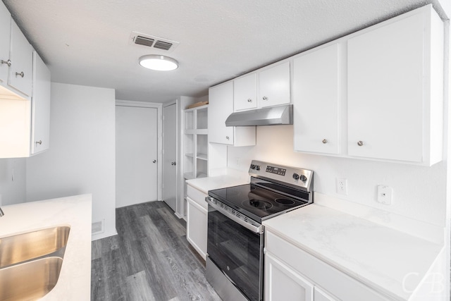 kitchen featuring a textured ceiling, stainless steel range with electric cooktop, white cabinets, and sink