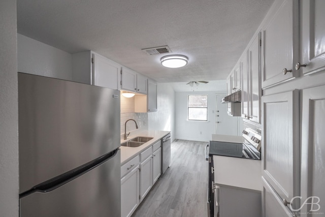 kitchen with sink, white cabinetry, appliances with stainless steel finishes, and tasteful backsplash