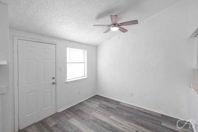 entrance foyer featuring a textured ceiling, dark wood-type flooring, lofted ceiling, and ceiling fan