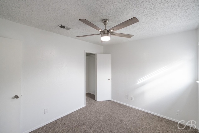 carpeted empty room with ceiling fan and a textured ceiling