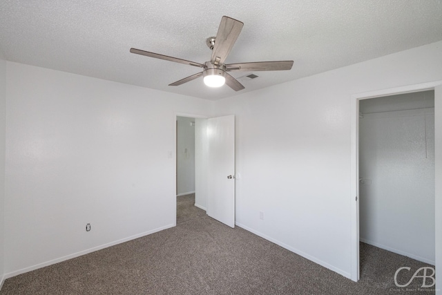 unfurnished bedroom featuring ceiling fan, a closet, dark carpet, and a textured ceiling