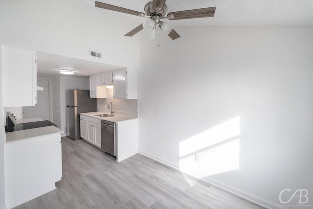 kitchen with white cabinets, stainless steel appliances, sink, backsplash, and ceiling fan