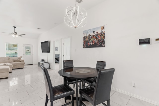 dining room featuring light tile patterned flooring, ceiling fan with notable chandelier, and vaulted ceiling