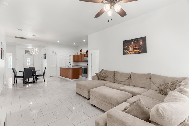 living room with sink, light tile patterned floors, and ceiling fan