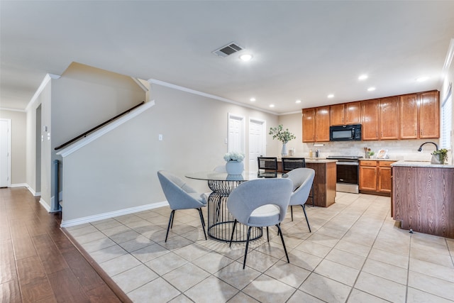 kitchen featuring light hardwood / wood-style flooring, tasteful backsplash, crown molding, and stainless steel range