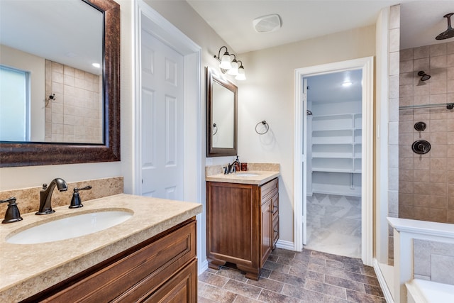 bathroom featuring a tile shower, tile patterned flooring, and double vanity