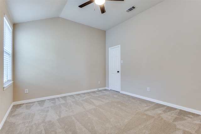 carpeted empty room with ceiling fan and vaulted ceiling