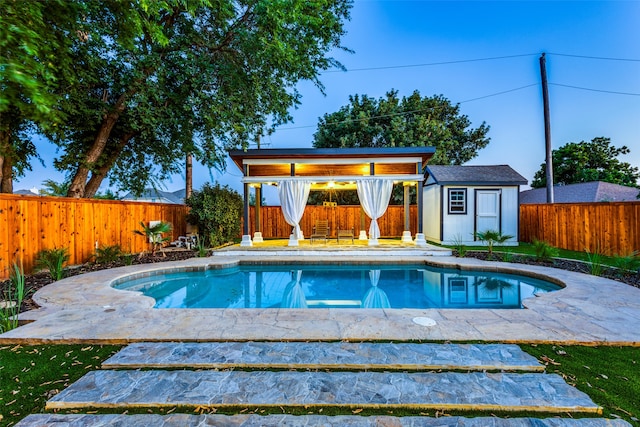 view of swimming pool with a shed and a patio