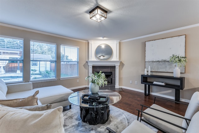 living room featuring ornamental molding, a tiled fireplace, and hardwood / wood-style floors