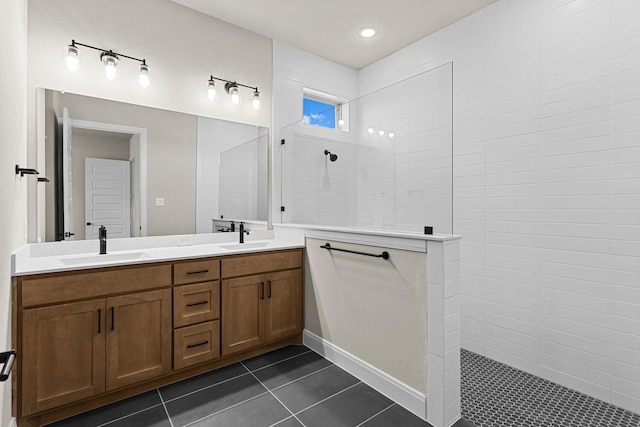 bathroom with vanity, a tile shower, and tile patterned floors