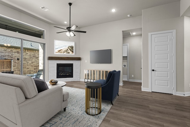 living room featuring dark wood-type flooring and ceiling fan