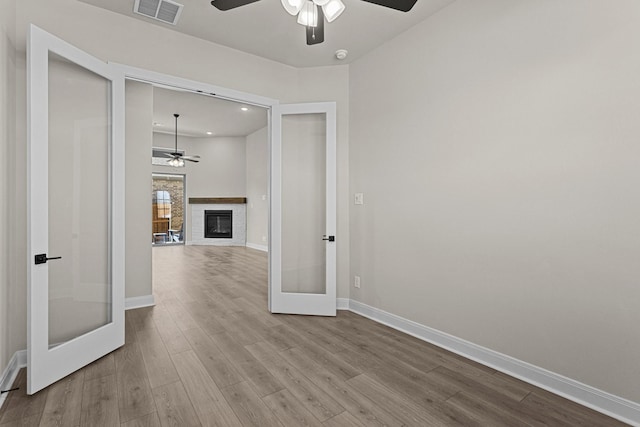 corridor with light hardwood / wood-style flooring and french doors