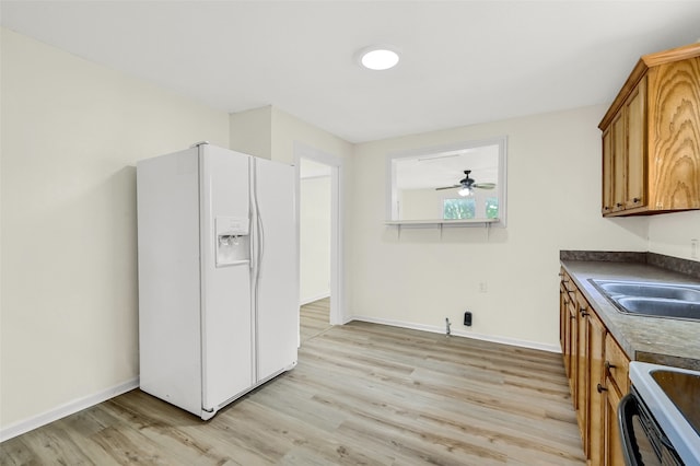 kitchen with light wood-type flooring, ceiling fan, stainless steel range oven, and white refrigerator with ice dispenser