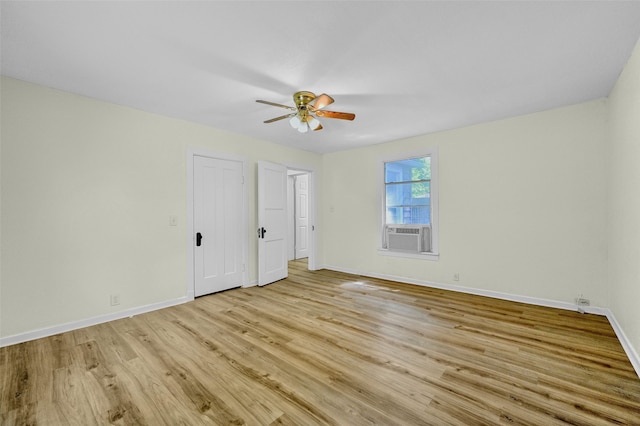 unfurnished bedroom with ceiling fan, cooling unit, light hardwood / wood-style flooring, and two closets