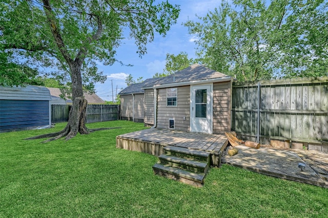 back of property with a storage shed, a wooden deck, and a yard