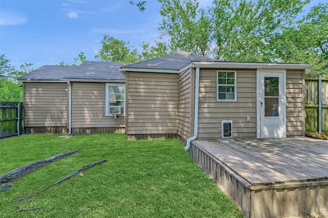 back of property with a deck and a lawn