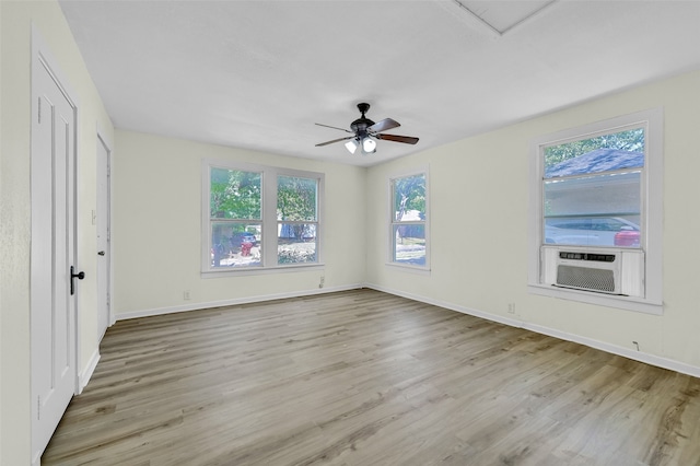 unfurnished room with ceiling fan, cooling unit, and light hardwood / wood-style flooring