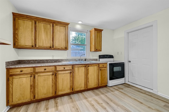 kitchen with white electric range, light wood-type flooring, and sink