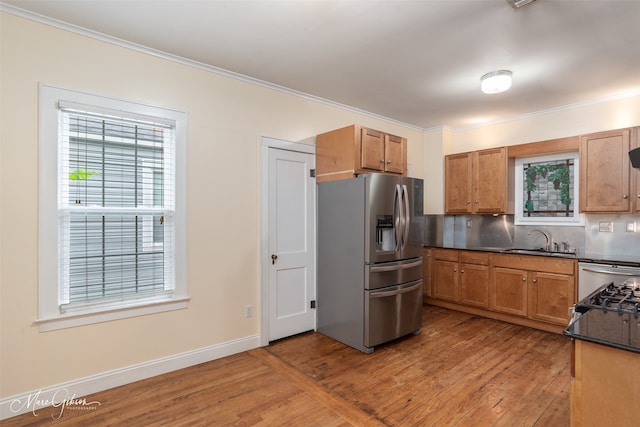 kitchen featuring sink, wood-type flooring, stainless steel fridge with ice dispenser, and backsplash