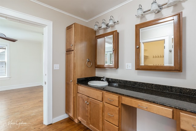 bathroom featuring plenty of natural light, vanity, crown molding, and wood-type flooring