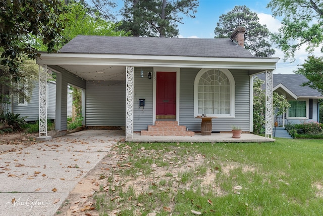 view of front of home with a carport and a front lawn