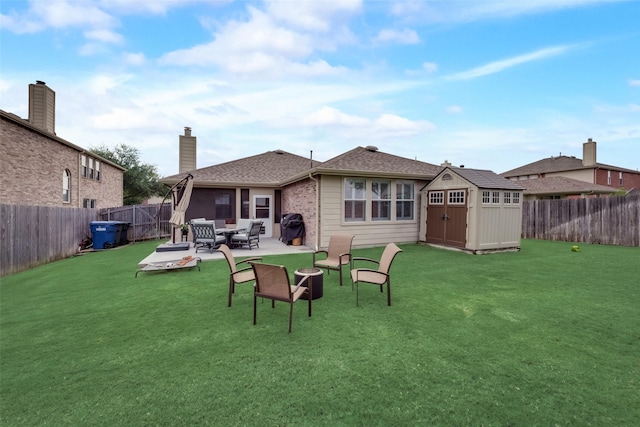 back of property featuring an outbuilding, a fenced backyard, a storage shed, a chimney, and a patio area