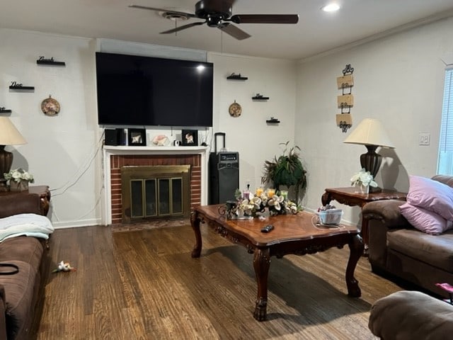 living room with ornamental molding, a brick fireplace, hardwood / wood-style floors, and ceiling fan