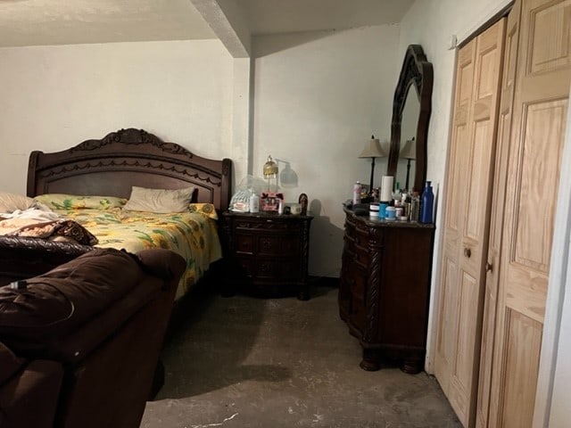 bedroom with a closet and concrete floors