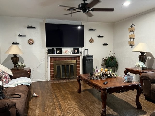 living room with ornamental molding, a fireplace, ceiling fan, and hardwood / wood-style floors