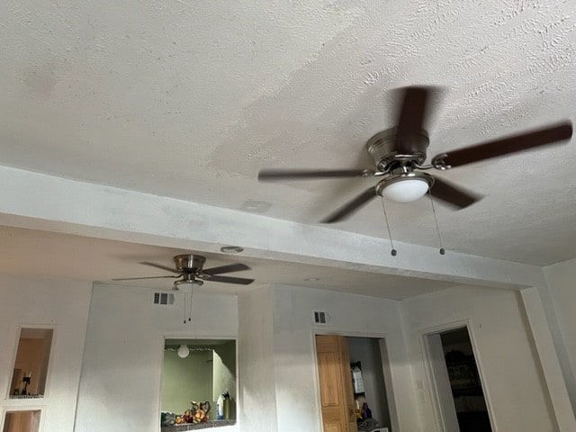 interior details with a textured ceiling and ceiling fan