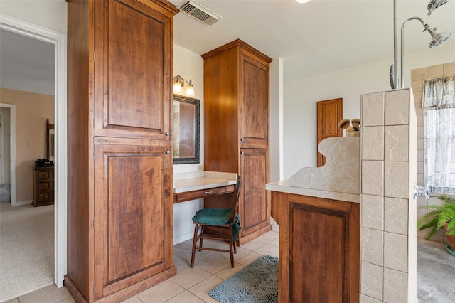 kitchen featuring built in desk and light tile patterned floors