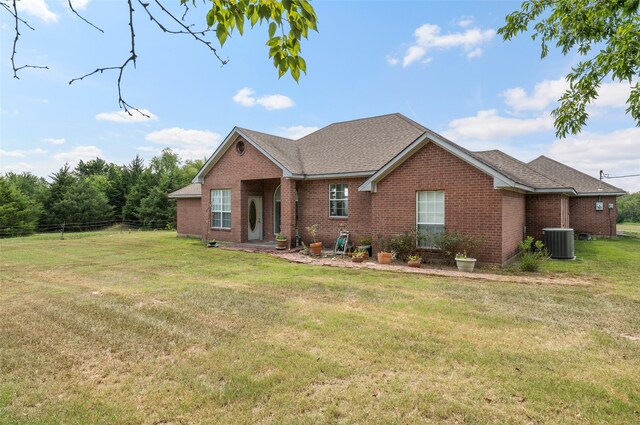 ranch-style house featuring central AC and a front yard