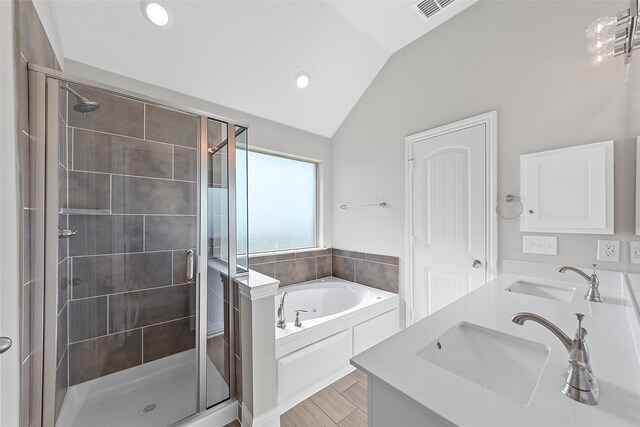 bathroom featuring dual vanity, shower with separate bathtub, and lofted ceiling