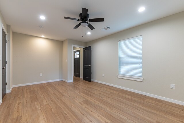 unfurnished bedroom featuring ceiling fan, multiple windows, and light wood-type flooring