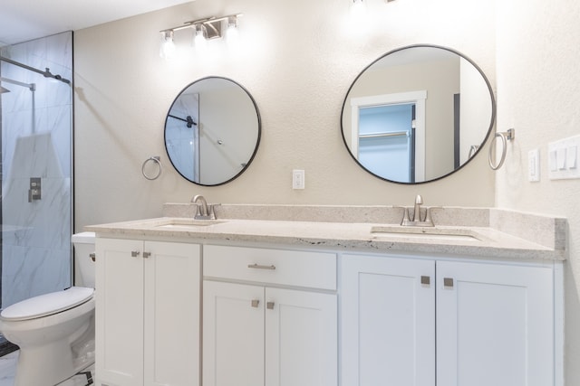 bathroom featuring toilet, vanity, and tiled shower