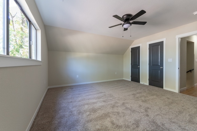 additional living space with ceiling fan, carpet, and lofted ceiling