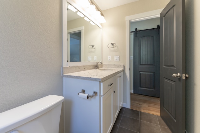 bathroom with vanity, toilet, and hardwood / wood-style floors